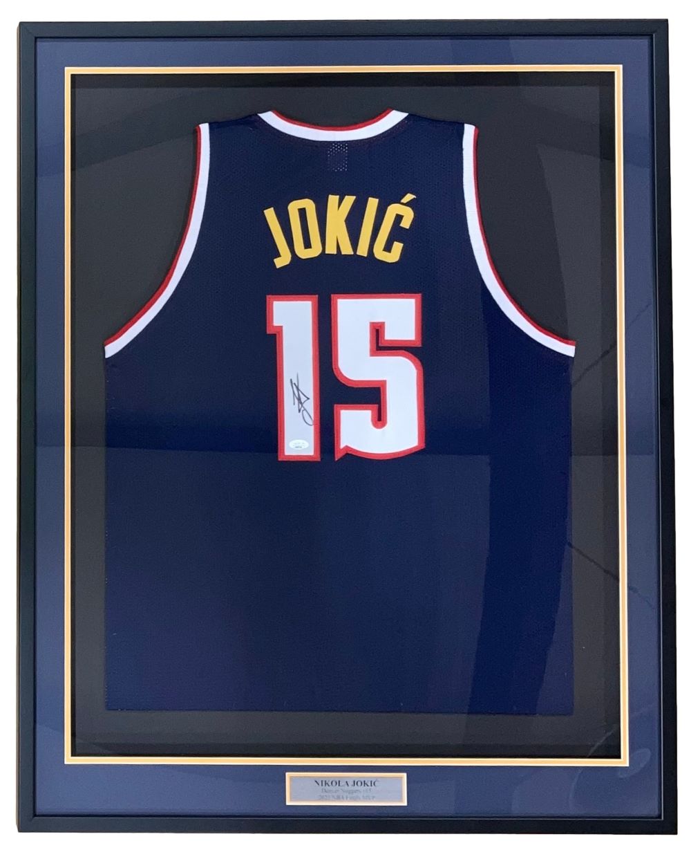 The Sports Integrity Nikola Jokic Denver Signed Framed Navy Blue Basketball Jersey (JSA) features "JOKIĆ" and number 15, autographed and displayed behind glass with a nameplate at the bottom.