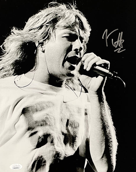 The Sports Integrity Joe Elliott Signed 11x14 Black and White Def Leppard Photo (JSA ITP) features the long-haired singer passionately performing onstage, T-shirted, gripping a mic, with his autograph in the upper right corner.