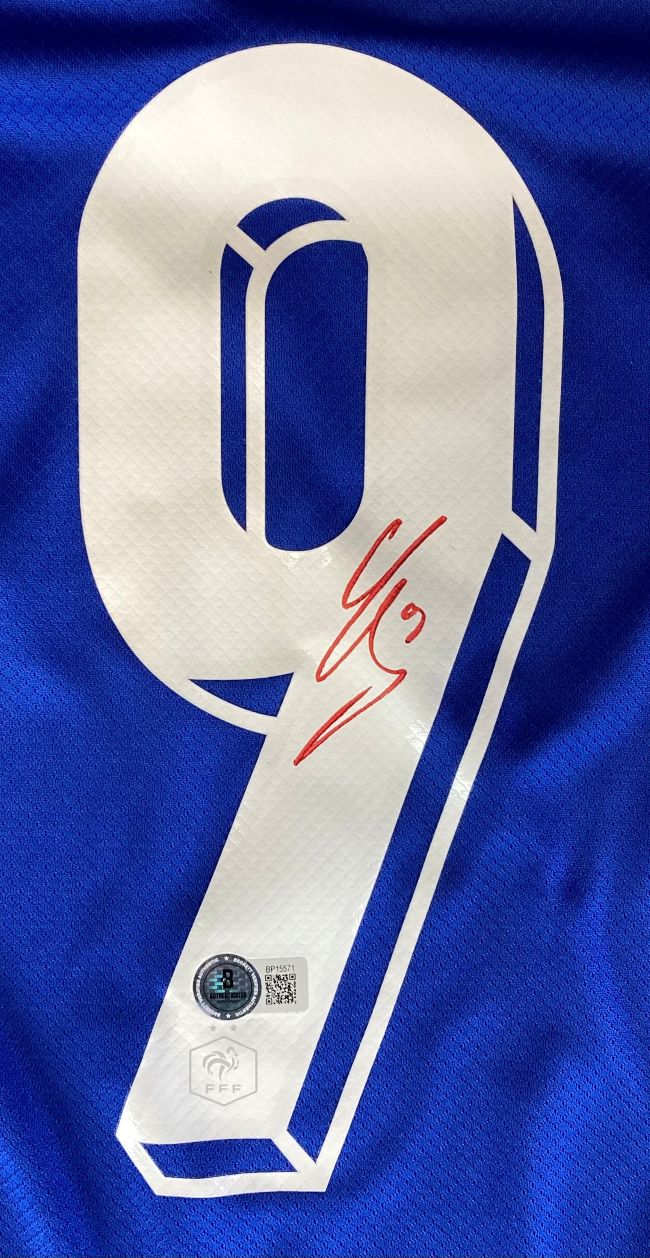 A white number 9 is printed on this blue France Nike soccer jersey, autographed in red by Olivier Giroud. Two authentication stickers with QR codes and logos are on the lower part. Offered by Sports Integrity, BAS authenticated.