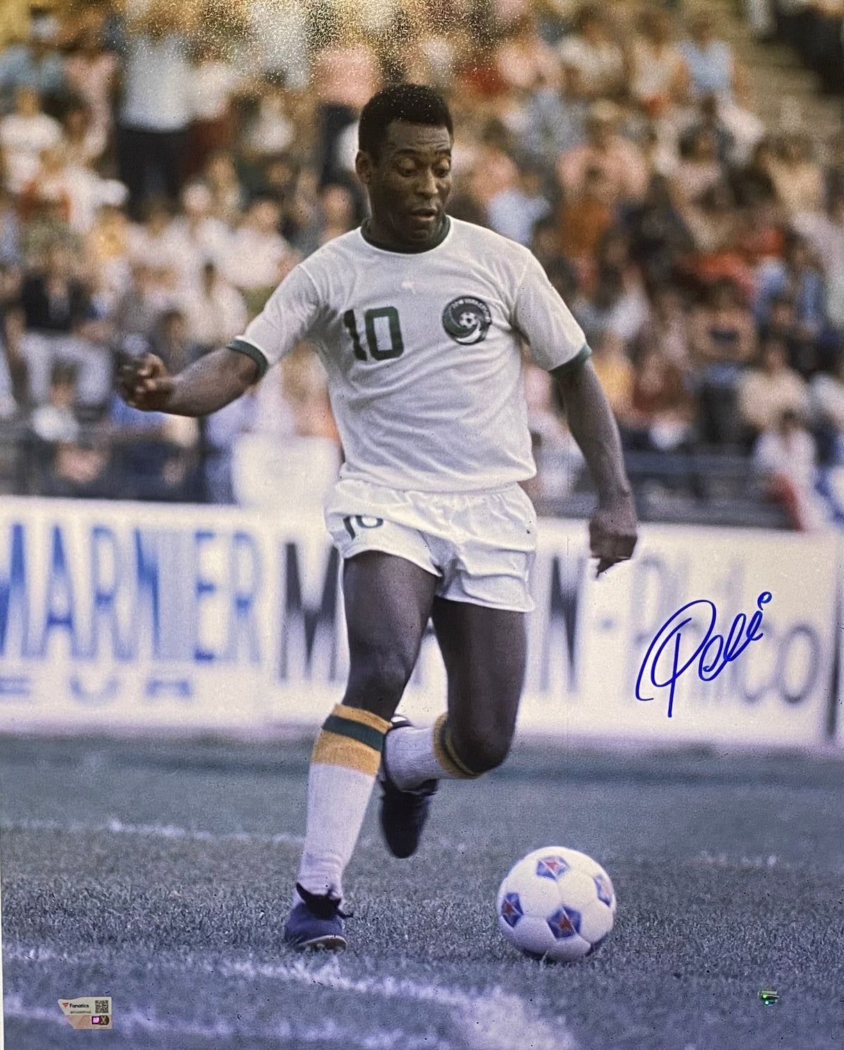 The Sports Integrity Pele Signed 16x20 Soccer Dribbling Photo shows Pele in a white #10 uniform about to kick a ball on the field, with a stadium and crowd in the background and a blue autograph on the lower right.