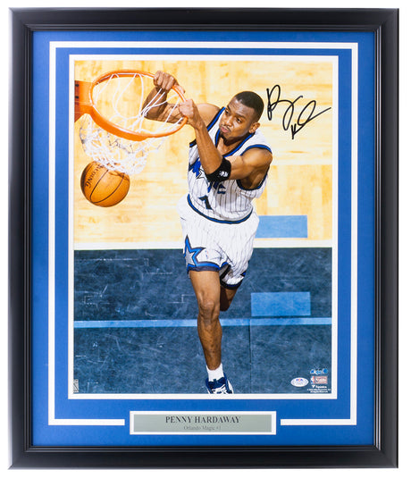 The Sports Integrity Penny Hardaway Signed Framed Orlando Magic 16x20 Dunk Photo features a PSA hologram and showcases Hardaway mid-air, about to dunk in his Magic jersey, with a nameplate reading "PENNY HARDAWAY Orlando Magic #1.