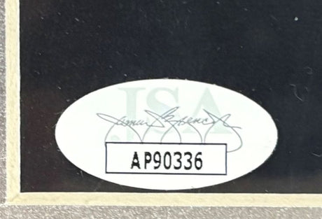 A close-up of the oval JSA authentication sticker with code AP90336 on the Post Malone Signed Framed 11x14 Photo by Sports Integrity.