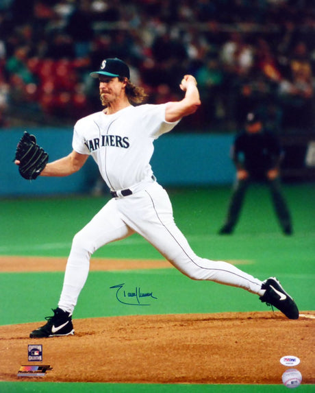 The Sports Integrity Randy Johnson Signed 16x20 Seattle Mariners Photo (PSA/DNA) shows Johnson pitching in a white uniform on the mound, with an umpire and crowd visible in the background.