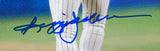 A close-up of a blue autograph on the Sports Integrity Reggie Jackson Signed Framed 8x10 New York Yankees Home Run Photo, showing a person in white pinstriped pants on a baseball field.