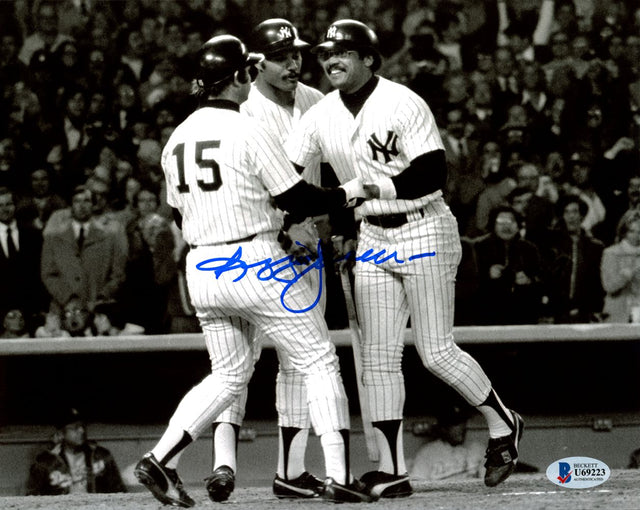 Three New York Yankees in pinstripes celebrate on the field in this Sports Integrity Reggie Jackson Signed B&W 8x10 Photo (BAS), with a blue autograph visible and cheering fans in the background.