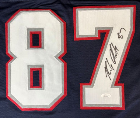 The Sports Integrity Rob Gronkowski New England Signed Alternate Blue Football Jersey features a large white and red-trimmed number 87 with his autograph on the number 7 and a JSA hologram authentication sticker.