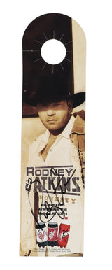 A 3x10 Dr. Pepper bottle advertisement signed by Rodney Atkins, featuring a sepia-toned image of him in a cowboy hat and coat, from Sports Integrity. Includes Dr Pepper, Diet Dr Pepper, and Cherry Vanilla Dr Pepper logos.
