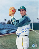 The Sports Integrity Rollie Fingers Signed 8x10 Oakland Athletics Baseball Photo (BAS 622) features Fingers in uniform on the field, holding a glove and ball, with empty blue bleachers and palm trees in the background.