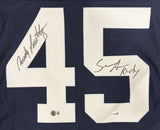 Sports Integrity Rudy Ruettiger Sean Astin Notre Dame Signed Blue "Never Quit" Jersey features a large white 45 with two black signatures, BAS+JSA certification stickers near the bottom.