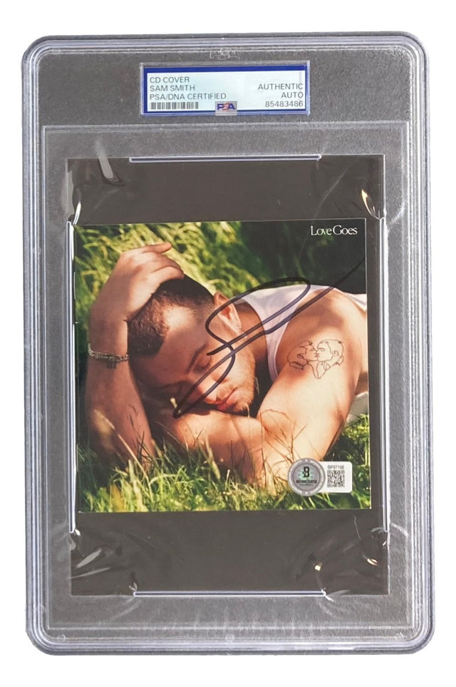 The Sam Smith Signed Slabbed Love Goes CD Booklet by Sports Integrity is PSA authenticated and features Sam Smith outdoors with a visible arm tattoo, all encased in a clear plastic holder.