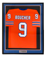 Sports Integrity Adam Sandler The Waterboy custom Boucher football jersey, framed, features orange fabric with "BOUCHER" and #9 (autographed) on the back, blue/white sleeve stripes, and a plaque at the frame's bottom. JSA certified.