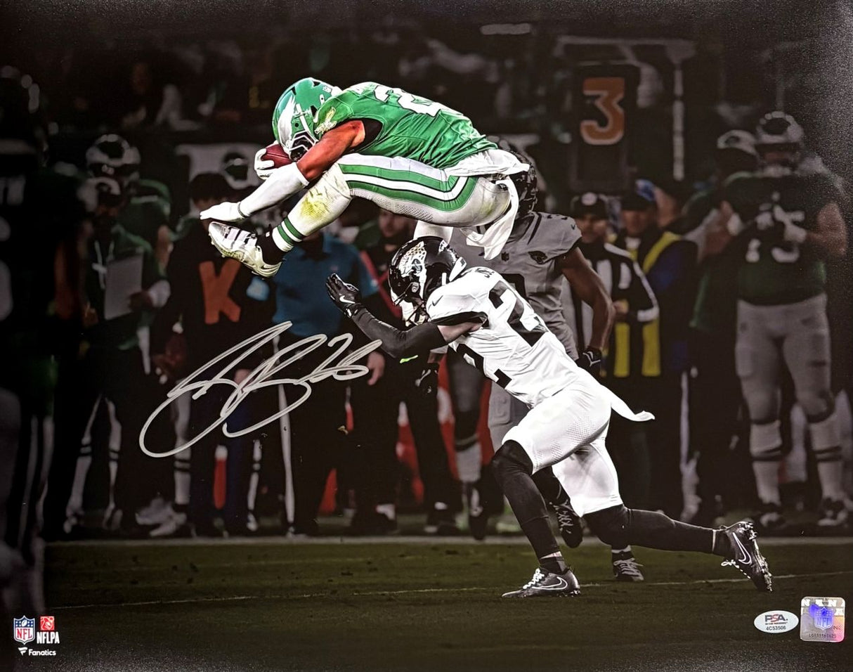 Saquon Barkley Signed 16x20 Eagles Reverse Hurdle Spotlight Photo by Sports Integrity shows Barkley in a green uniform leaping over a defender, with his signature and a blurred stadium background. PSA/DNA ITP authenticated.