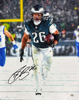 Saquon Barkley runs with the ball in a green Eagles jersey on a snowy field in this signed 16x20 photo of the Eagles vs Rams game. PSA/DNA ITP authenticated. Available from Sports Integrity.