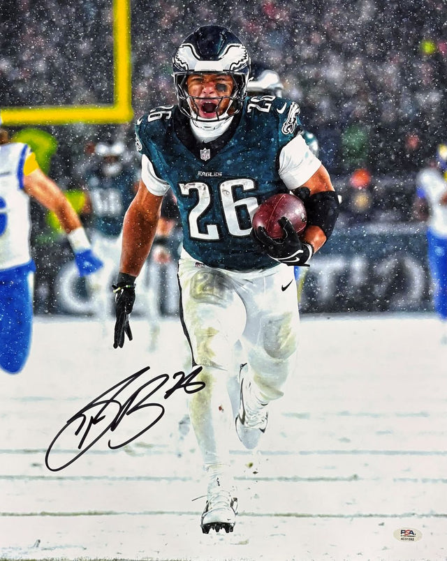 Saquon Barkley runs with the ball in a green Eagles jersey on a snowy field in this signed 16x20 photo of the Eagles vs Rams game. PSA/DNA ITP authenticated. Available from Sports Integrity.
