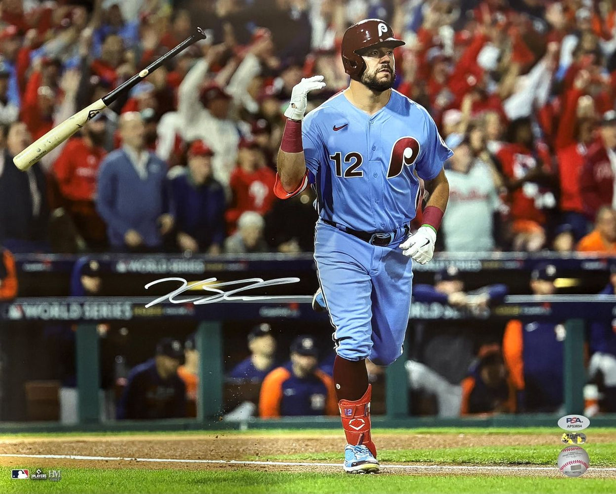 The Sports Integrity Kyle Schwarber Signed 16x20 Philadelphia Phillies Blue Jersey Photo (PSA/DNA) shows Schwarber flipping his bat as fans cheer during the World Series, with official logos visible.