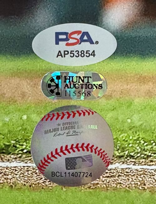 Close-up of three authentication stickers on the Kyle Schwarber Signed 16x20 Phillies Blue Jersey Photo by Sports Integrity: PSA (AP53854), Hunt Auctions (115568), and MLB hologram (BCL11407724).