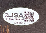Sports Integrity Sean Astin Signed 11x17 Rudy Photo features an oval sticker with JSA Authenticated text, a scales of justice icon, QR code, and code CI84665 on a dark background.