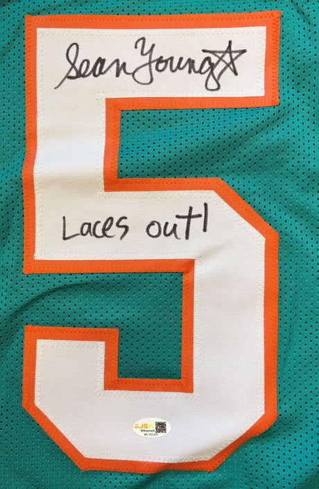 The Sports Integrity Sean Young Ace Ventura Signed Finkle Jersey features a teal design with an orange-outlined white number 5, “Laces Out!” inscription, and signature in black marker. Includes JSA QR authentication sticker.