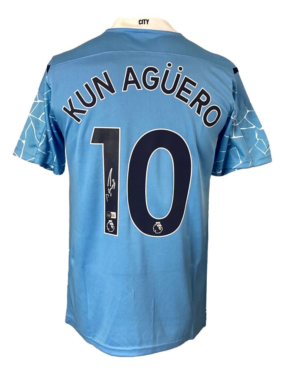 The Sports Integrity Sergio Aguero Signed Manchester City Puma Soccer Jersey BAS is light blue with "KUN AGÜERO" and number 10 on the back in dark letters, white sleeve patterns, and a small Premier League logo below the number.