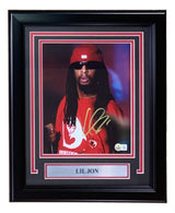 A Sports Integrity Lil Jon Signed Framed 8x10 Photo (BAS), featuring him in a red shirt and hat with long dreadlocks and sunglasses, displayed in a frame with a metal nameplate reading "LIL JON.