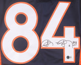 The Sports Integrity Shannon Sharpe Denver Navy Pro-Cut Football Jersey features large white and orange number 84, a black marker autograph across the 4, and a BAS authentication sticker below the signature.