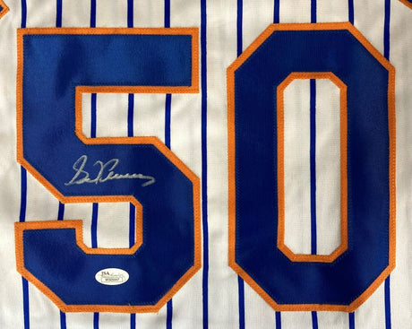 A close-up of the Sports Integrity Sid Fernandez New York Signed White Baseball Jersey (JSA), featuring blue vertical stripes, a bold blue and orange number 50 with his signature inside the “5,” and an authentication sticker below.