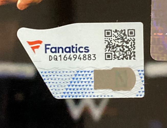 A close-up of a Fanatics authenticity sticker with QR code, logo, serial DQ16494883, and hologram, shown on the Solo Sikoa Signed Framed 8x10 WWE Photo by Sports Integrity.