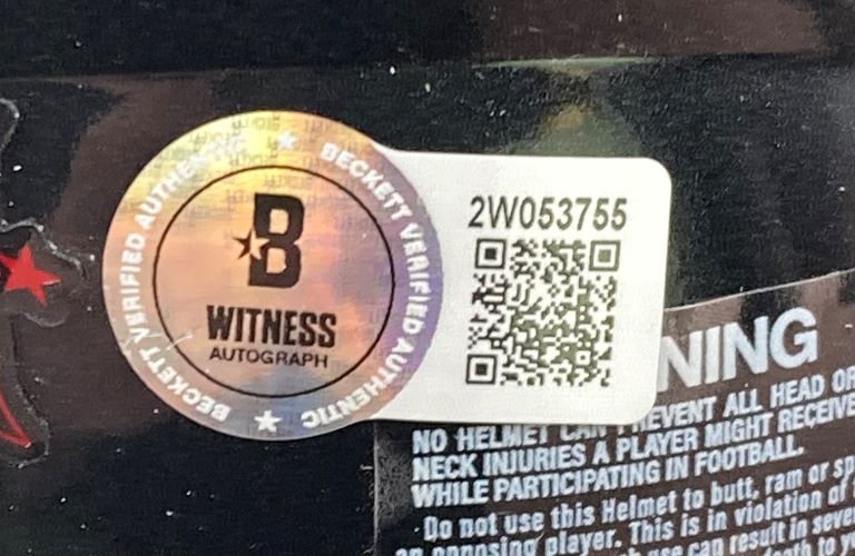 A Beckett Witnessed authentication sticker and a white label with QR code and “2W053755” are attached to the Sports Integrity Stefon Diggs Signed Houston Texans Mini Speed Helmet BAS w/ Case, partly covering a warning label.