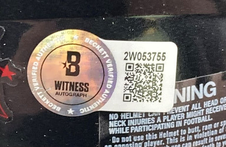 A Beckett Witnessed authentication sticker and a white label with QR code and “2W053755” are attached to the Sports Integrity Stefon Diggs Signed Houston Texans Mini Speed Helmet BAS w/ Case, partly covering a warning label.