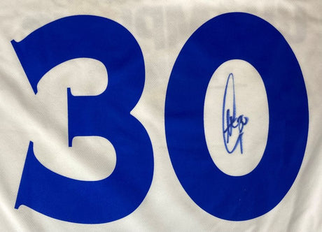 The Stephen Curry Signed Warriors Adidas Basketball Jersey 2017 Champions by Sports Integrity features white fabric with a large blue number 30, and Curry’s signature inside the zero.