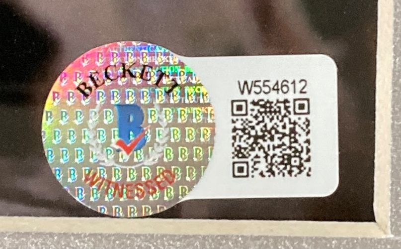 A holographic Beckett sticker and white label with QR code and W554612 are attached to the Stone Cold Steve Austin Signed Autographed Framed 16x20 WWE Photo BAS by Sports Integrity.
