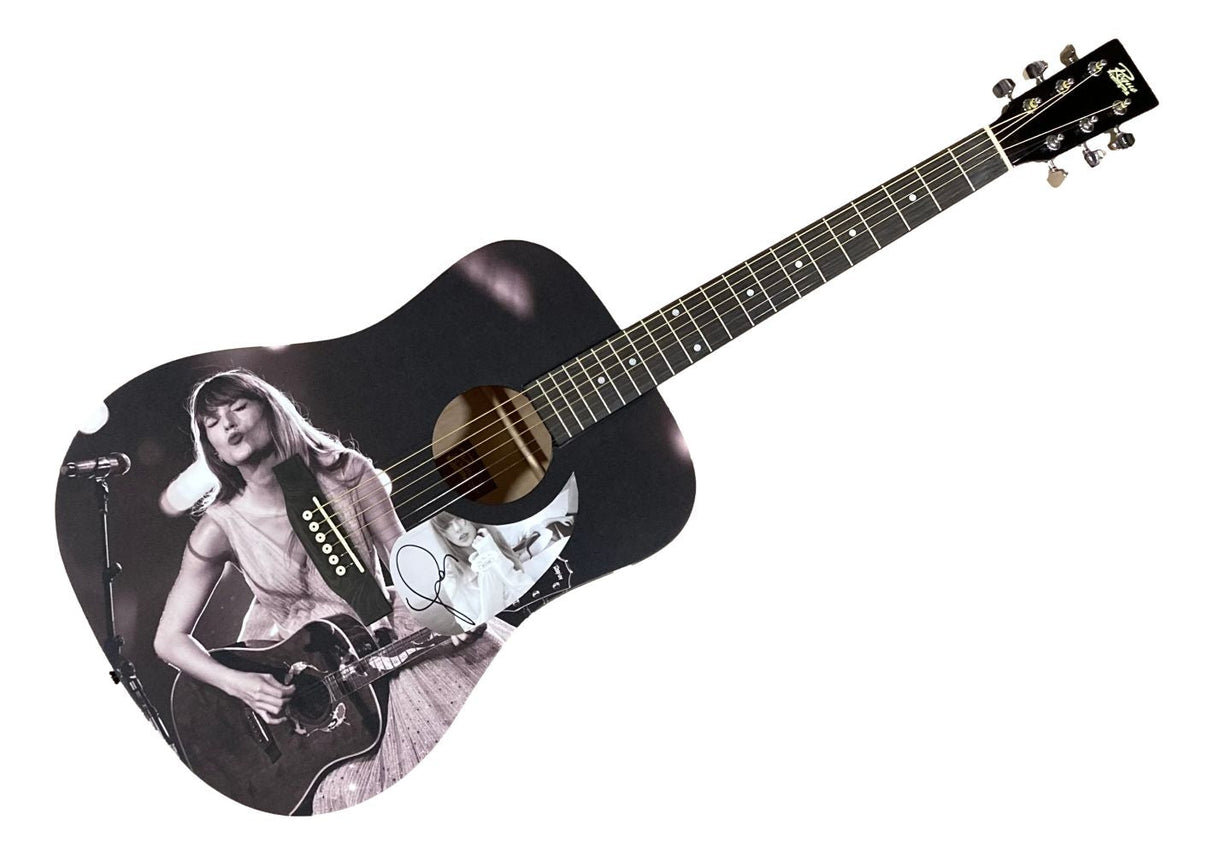 The Sports Integrity Taylor Swift Signed 41" Black & White Kiss Graphic Acoustic Guitar features a black finish with a black-and-white image of Taylor Swift singing and playing guitar printed on the body, plus her autograph near the lower edge.