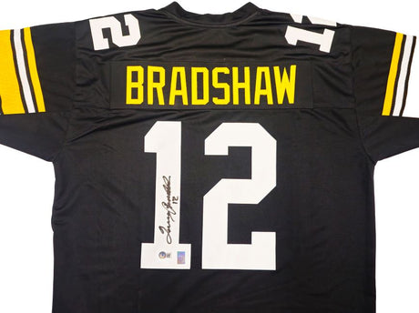 The Sports Integrity Terry Bradshaw Pittsburgh Signed Black Football Jersey BAS features yellow and white sleeve stripes, "BRADSHAW" and number 12 on the back, plus a signature on the number.