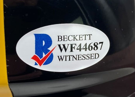 A Beckett oval sticker with "WF44687" and "WITNESSED" is attached to the Terry Bradshaw Signed Pittsburgh Steelers Mini Speed Helmet (Sports Integrity), stored in a display case.