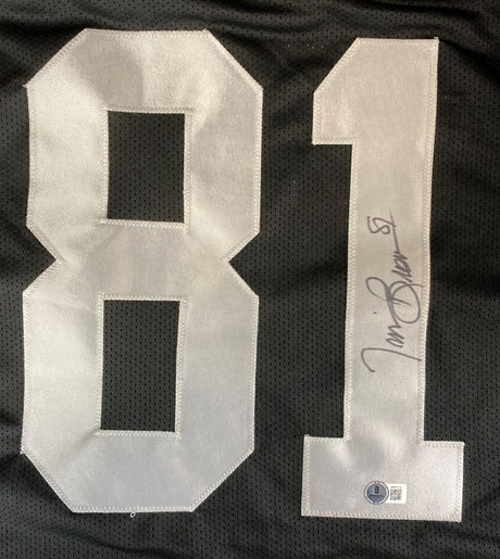 The Sports Integrity Tim Brown Oakland Signed Black Football Jersey BAS features large white 81 numbers, a mesh texture, and Tim Brown's black ink signature on the digit 1 with an authentication sticker near the bottom.