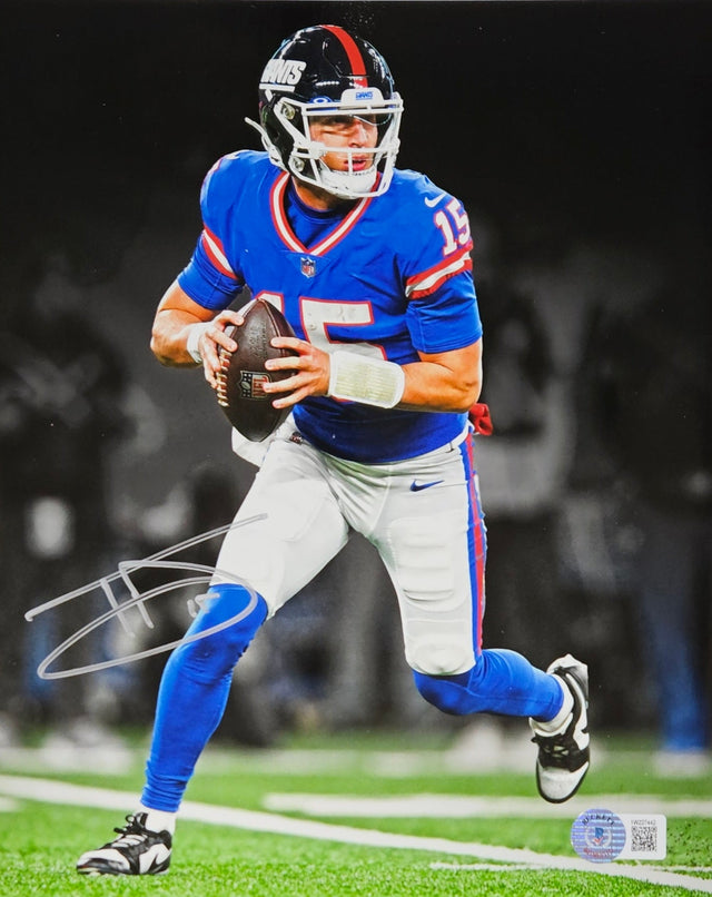 The Sports Integrity Tommy Devito Signed 8x10 New York Giants Photo (BAS ITP 1W227442) features Devito in his blue and red #15 uniform, holding a football ready to throw, with a black and white background highlighting the player in color.