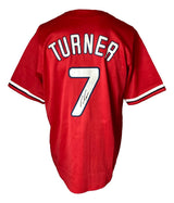 A Sports Integrity Trea Turner Philadelphia red baseball jersey with TURNER and #7 in white on the back, plus #7 featuring a black autograph below its left side. JSA authenticated.