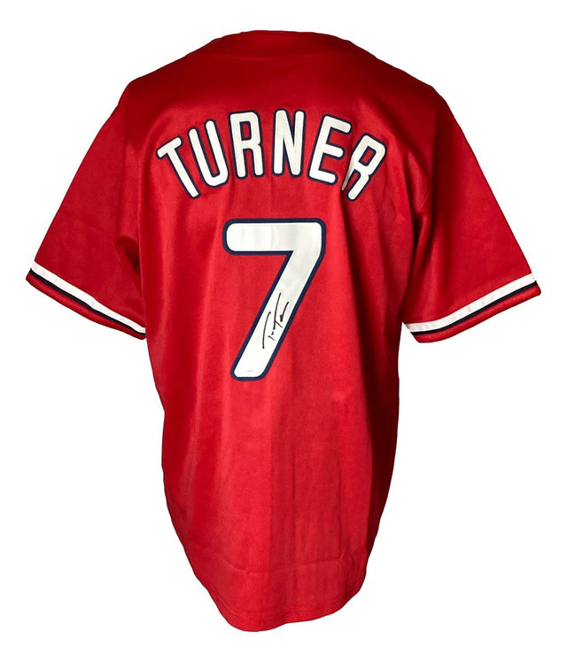 A Sports Integrity Trea Turner Philadelphia red baseball jersey with TURNER and #7 in white on the back, plus #7 featuring a black autograph below its left side. JSA authenticated.