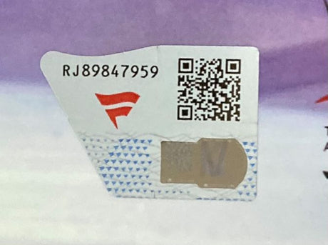 A close-up of the security label for the Sports Integrity Trish Stratus Signed Framed 8x10 WWE Entrance Photo by Fanatics, showing the code RJ89847959, red F logo, QR code, and scratch-off on a white and blue background.