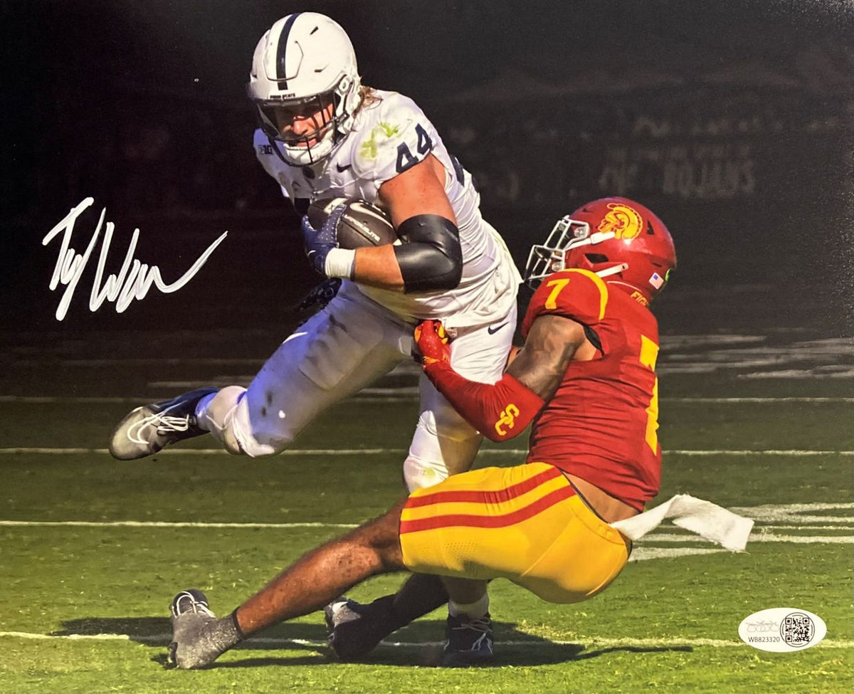 A Tyler Warren Signed 8x10 Penn State Nittany Lions vs USC Photo by Sports Integrity shows a football player in white running with the ball as a red and yellow player tackles him on a field at night, with an autograph visible.