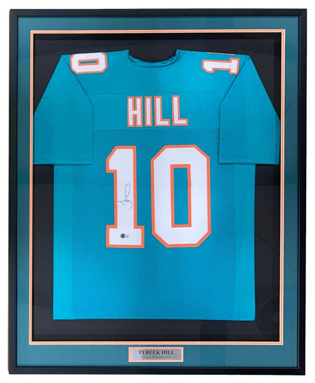The Sports Integrity Tyreek Hill Miami Signed Framed Custom Teal Football Jersey (BAS ITP) features white and orange "HILL 10" lettering, Tyreek Hill’s signature, and a nameplate at the bottom of the frame.