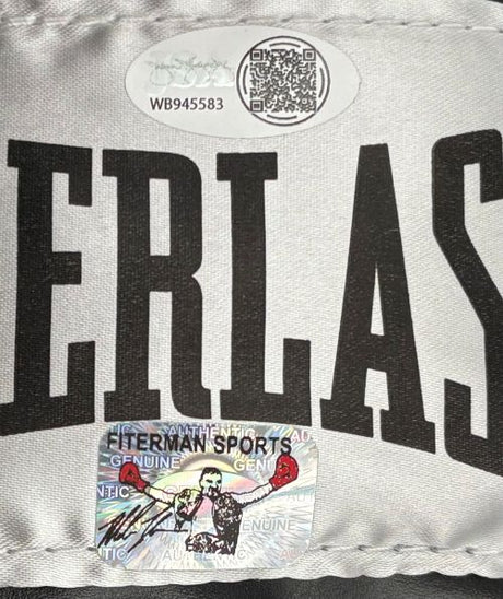 A Mike Tyson signed black Everlast right-hand boxing glove by Sports Integrity features JSA QR and holographic authentication stickers, with a case included. The glove displays bold white "ERLAS" lettering.