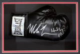A black Everlast right hand glove signed by Mike Tyson and Evander Holyfield is displayed in a black and red frame, offered by Sports Integrity.