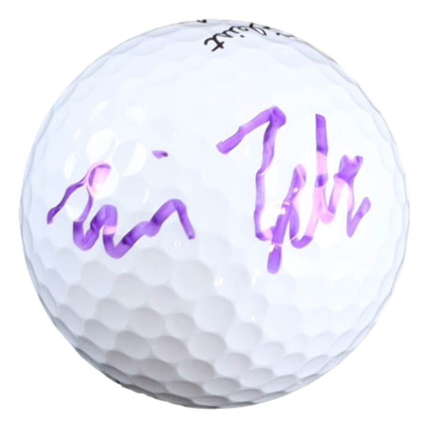 A Will Zalatoris signed PGA Titleist Pro V1 golf ball by Sports Integrity, featuring his purple signature on its white surface.