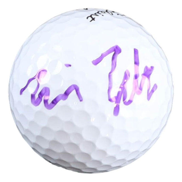 A Will Zalatoris signed PGA Titleist Pro V1 golf ball by Sports Integrity, featuring his purple signature on its white surface.