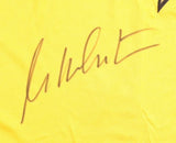 A William Shatner autograph appears in black ink on a yellow Star Trek Captain Kirk costume shirt by Sports Integrity, authenticated by JSA. The signature is stylized and not clearly legible.