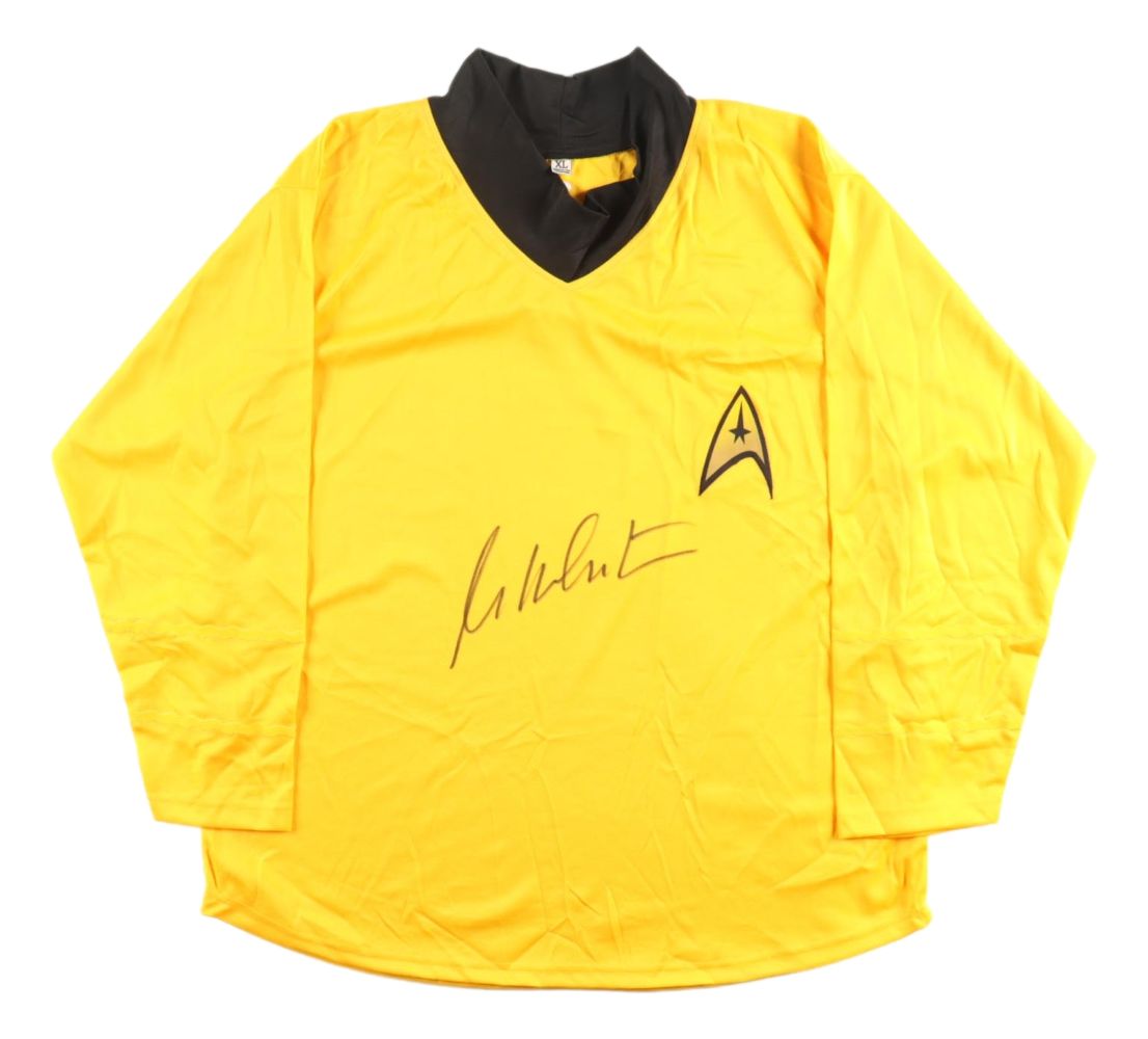 The Sports Integrity William Shatner Signed Star Trek Captain Kirk Costume Shirt features a long-sleeved yellow design with a black collar, Starfleet insignia, and Shatner's autograph below it.