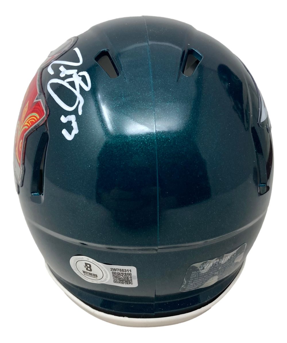 The Sports Integrity Zack Baun Signed Philadelphia Eagles Super Bowl 59 Mini Speed Helmet BAS is a dark green mini helmet with a shiny finish, white signature on one side, authentication stickers on the back, and ventilation holes.